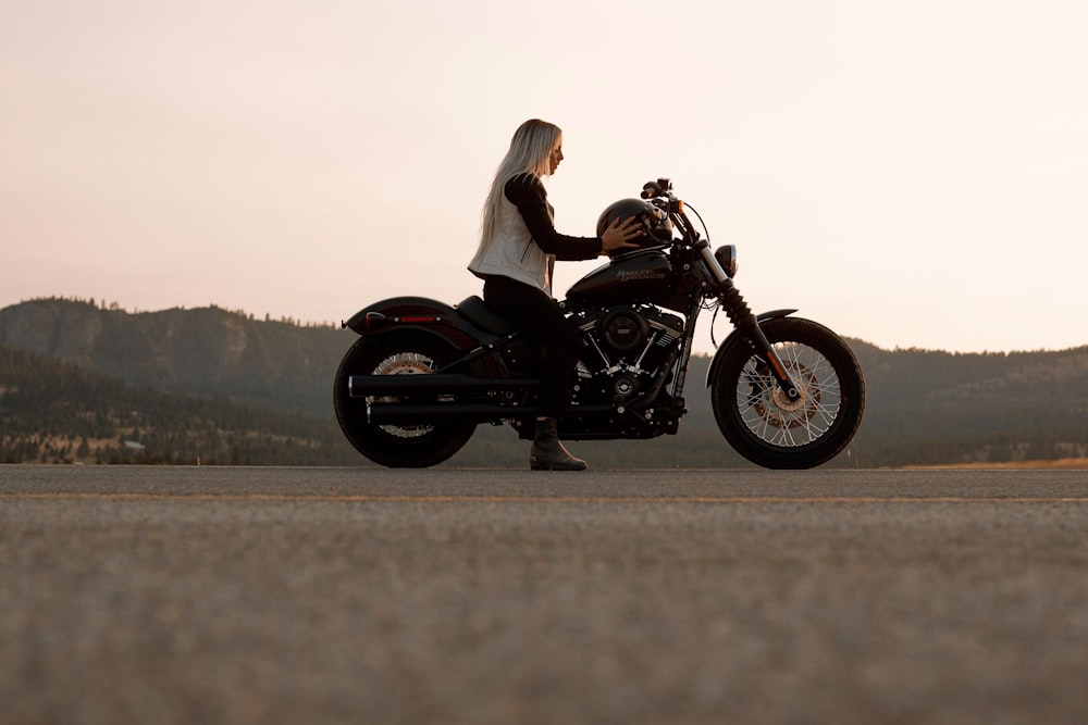 femme assise sur une moto cruiser noire et grise