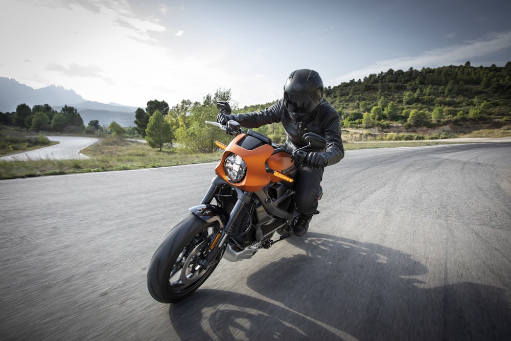 person driving orange motorcycle