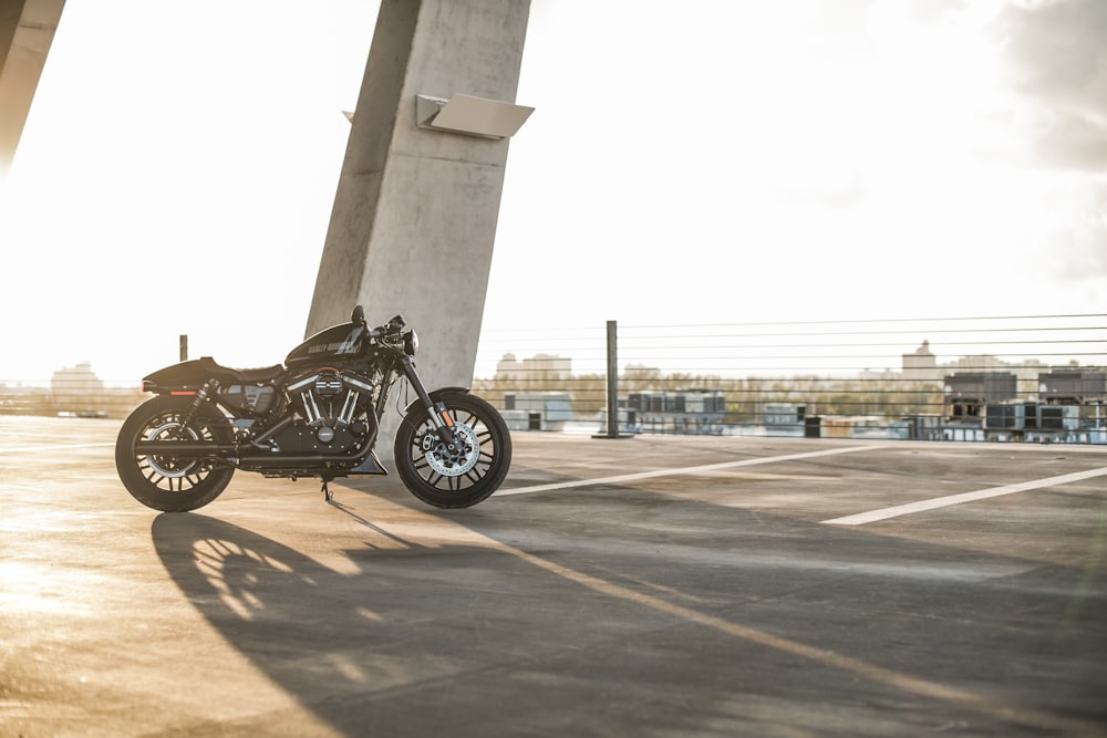 black motorcycle parked near grey concrete pillar