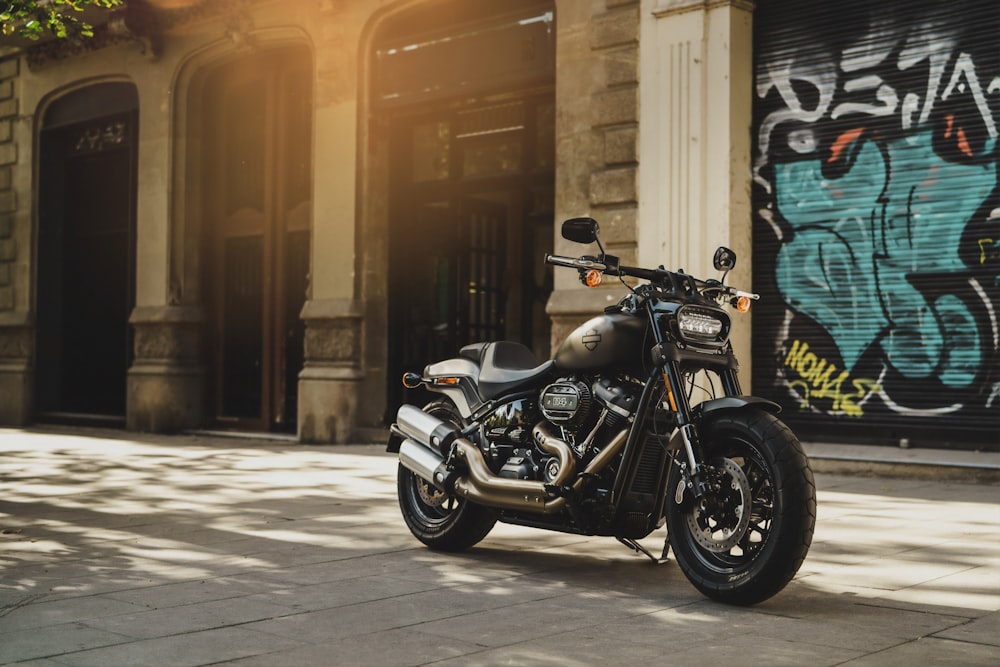 black motorcycle near wall with grafitti