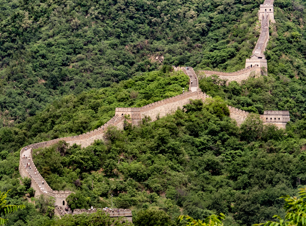 The Great Wall winding across densely forested mountains
