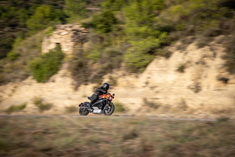 崖の近くでバイクに乗るヘルメットをかぶった男