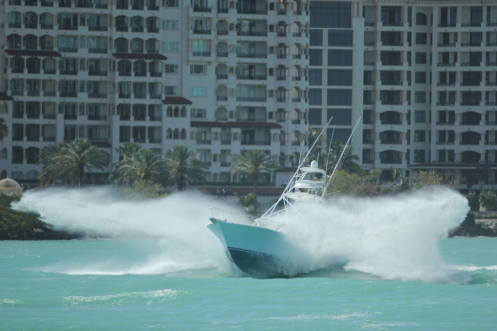 white and black powerboat in water leaving wake of mist