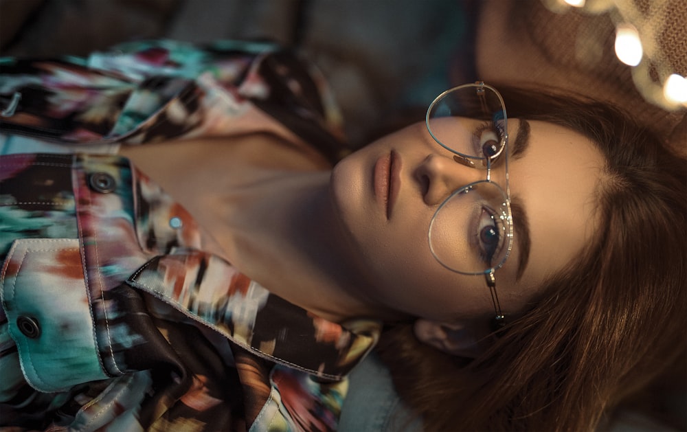 woman wearing blue, brown, and red floral button-up shirt and eyeglasses