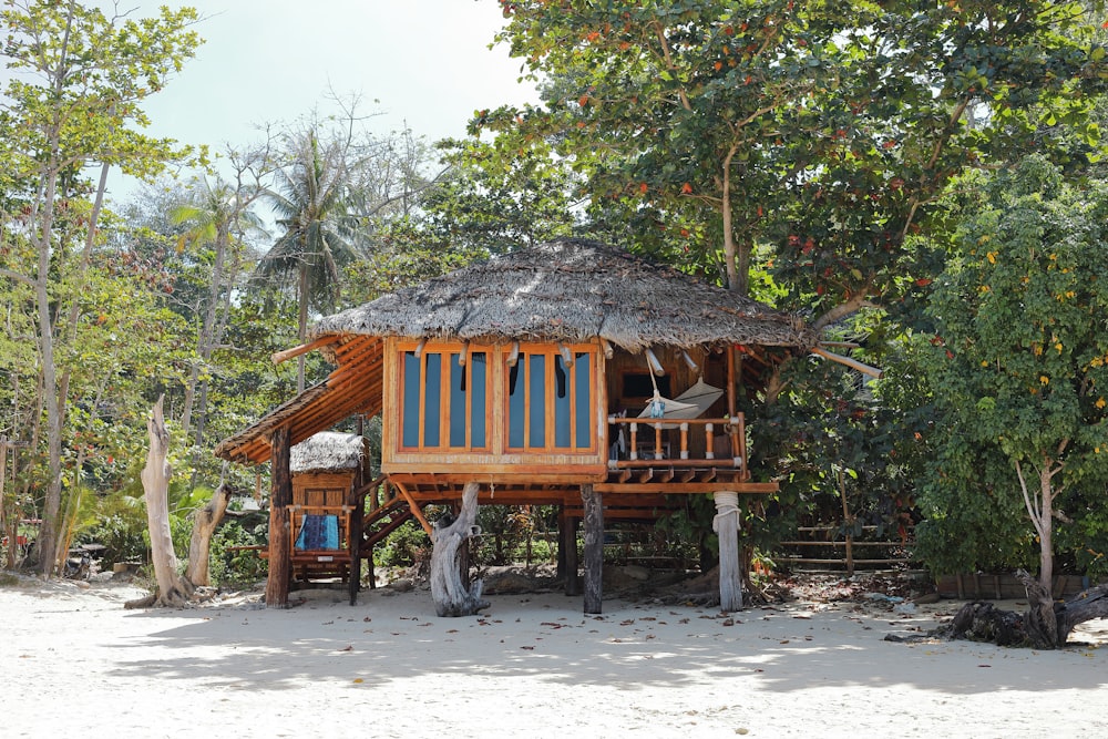 Cabana de madeira marrom sob a árvore durante o dia