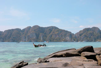 Solar-powered electric boat gliding quietly over clear coastal waters near a Thai island.