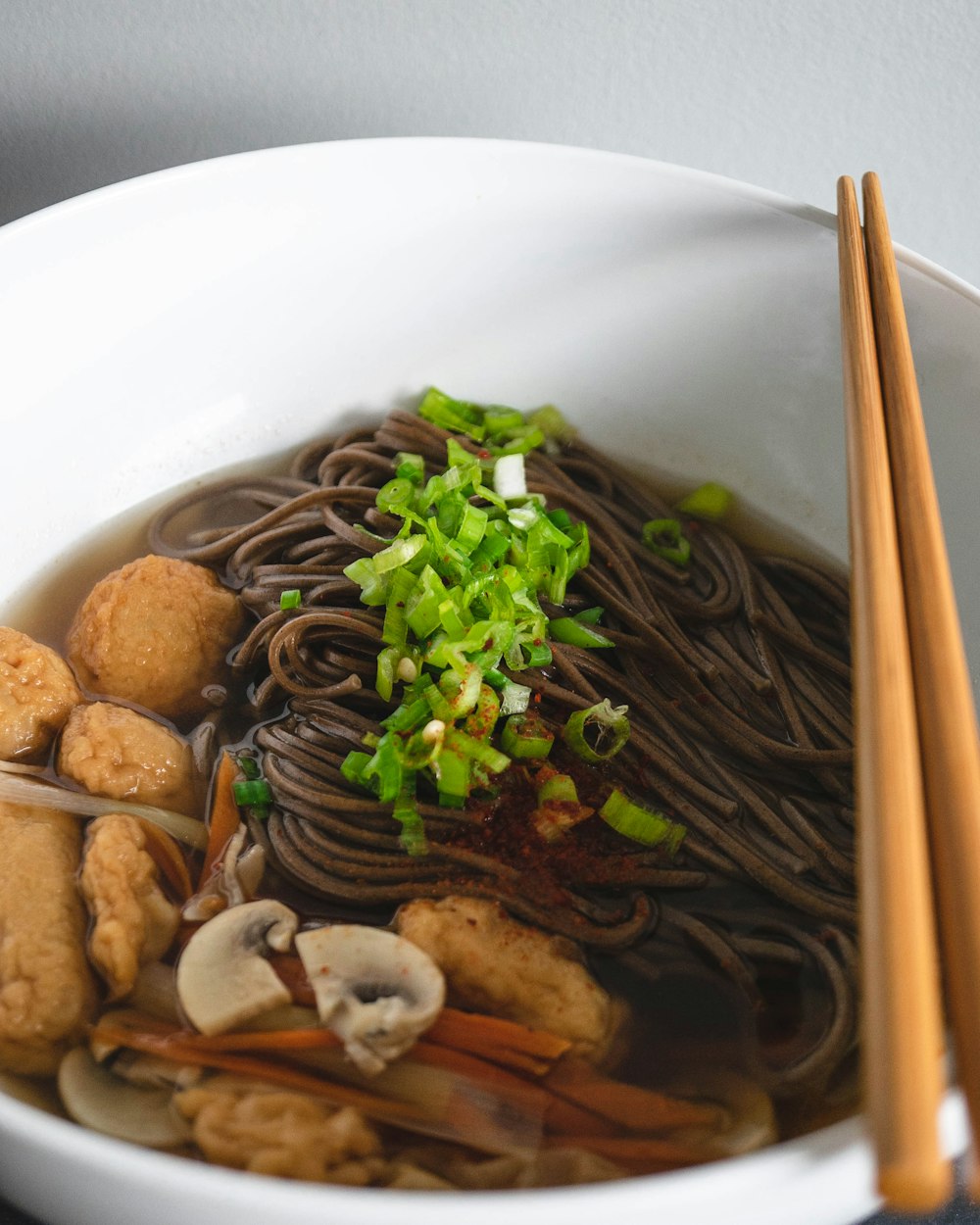 brown chopstick on bowl with noodle soup