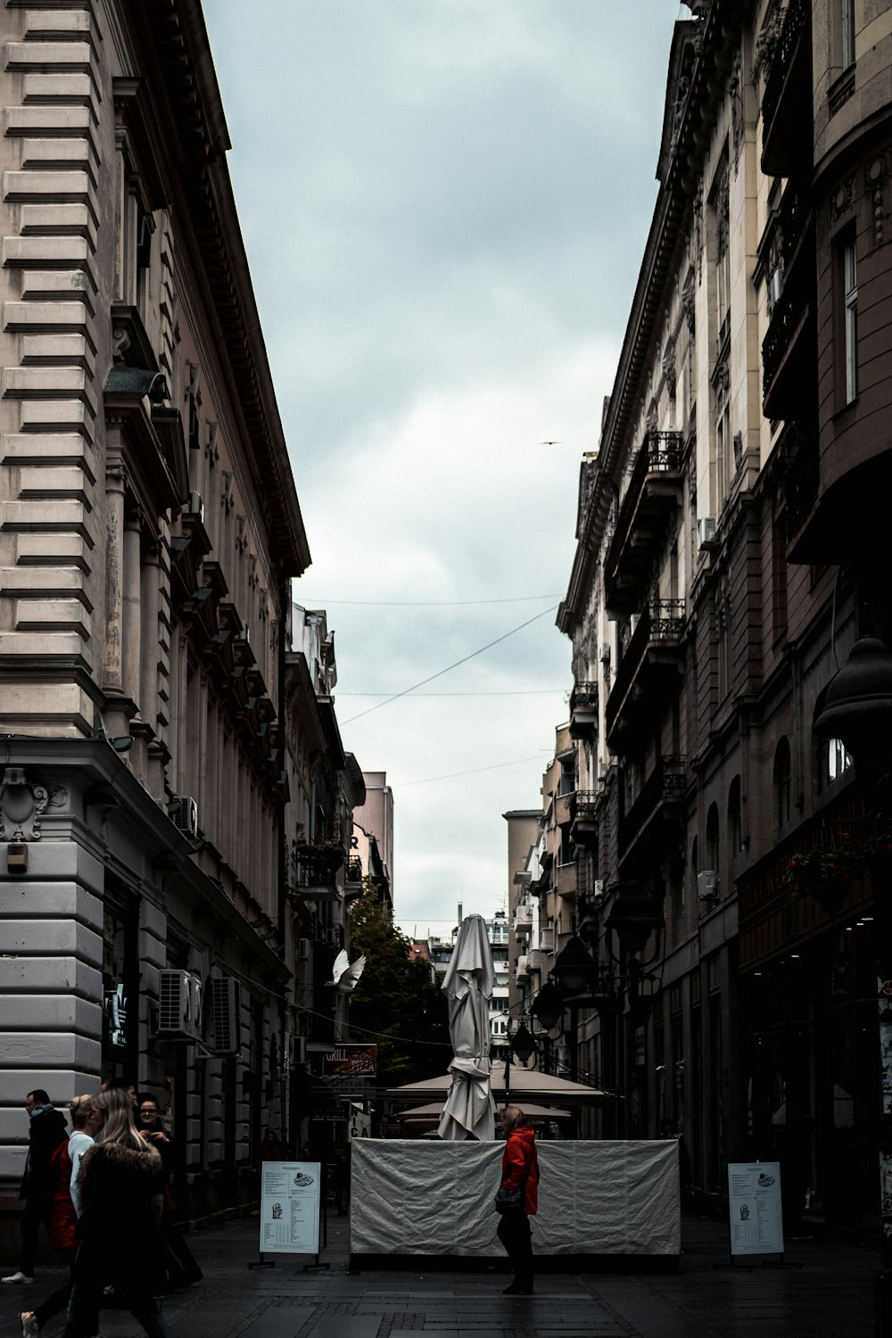 cars parked on street between buildings during daytime