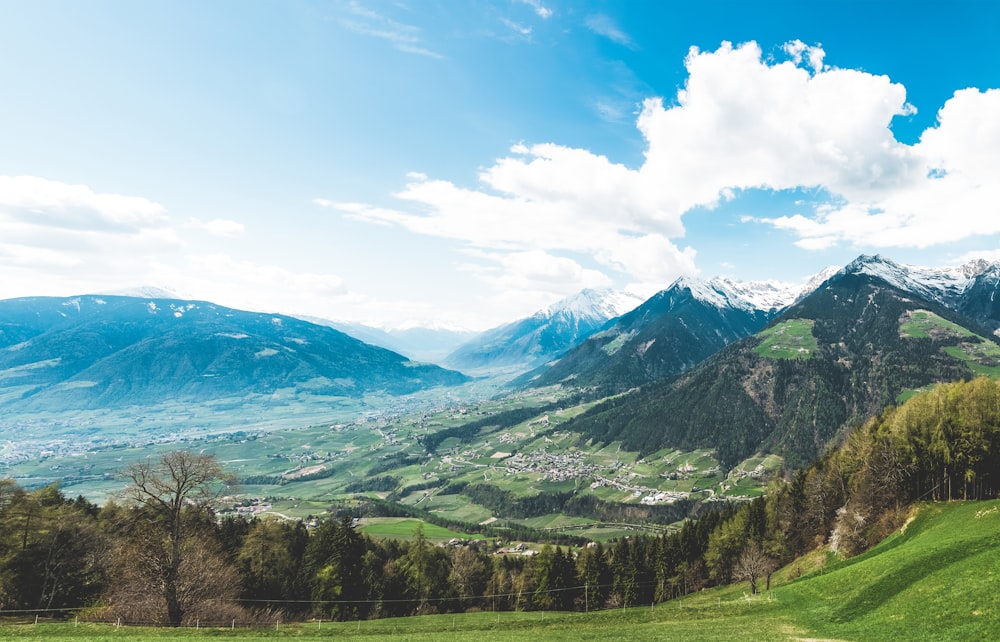 Weiße Wolken über hügeliger Landschaft