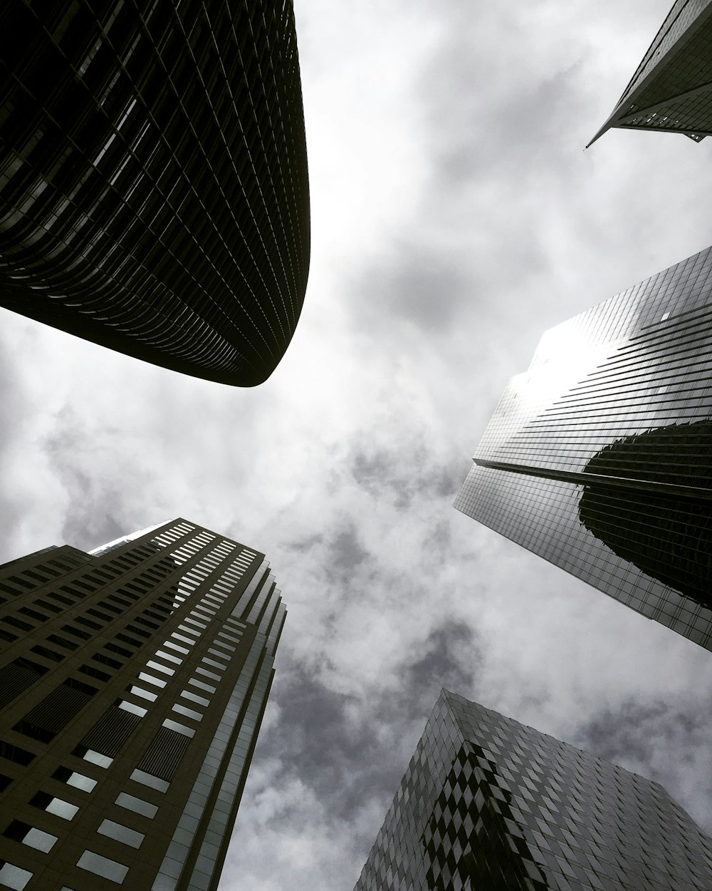 Fotografía de ángulo alto de un edificio con paredes de vidrio bajo cielos blancos y grises