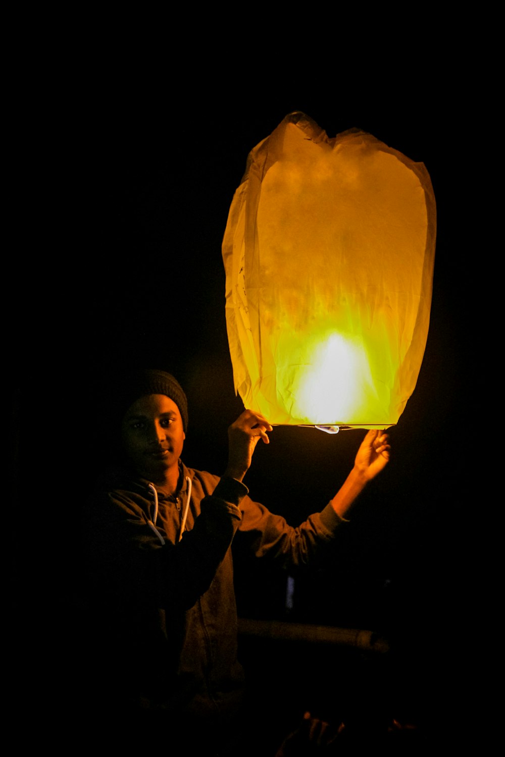 man holding a lighted paper lantern