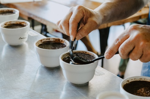 Close-up of a coffee taster evaluating aroma in a professional cupping session.
