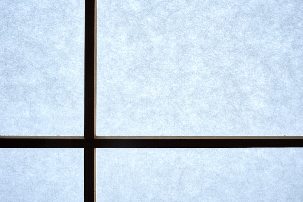 a window with a bird sitting on the window sill