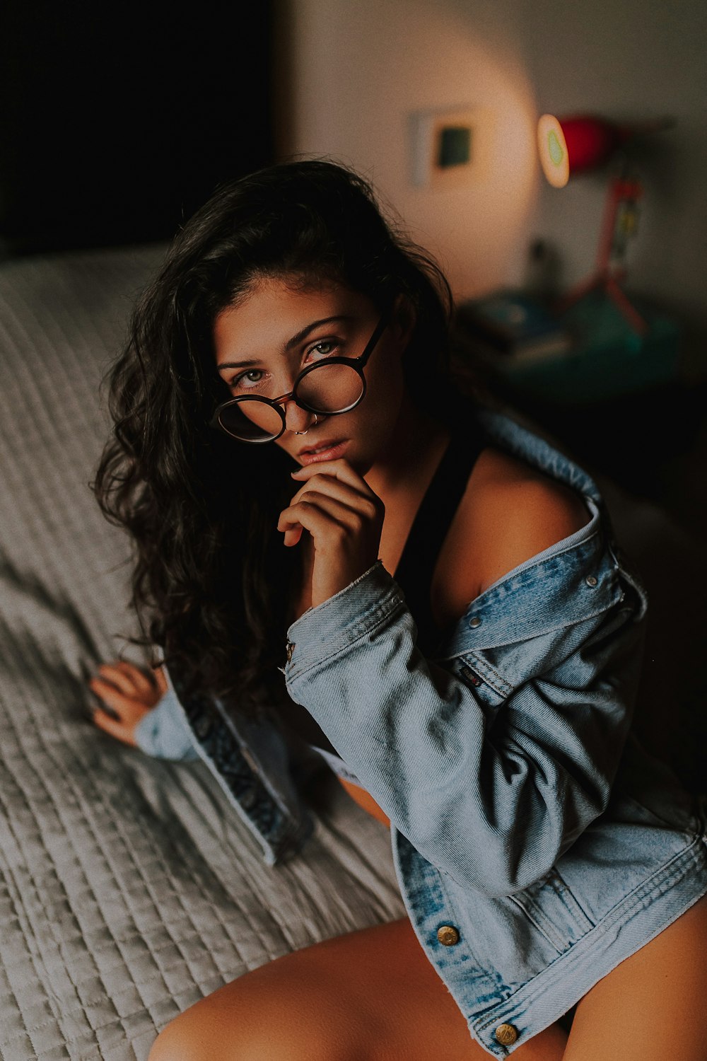 woman sitting on bed and touching her chin