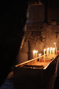 A serene photo of a softly lit memorial cloth draped gently over a wooden table with candles around.