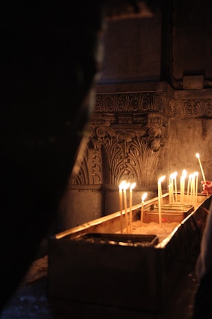 A serene moment of reflection with candles lit in a shared space honoring different beliefs.