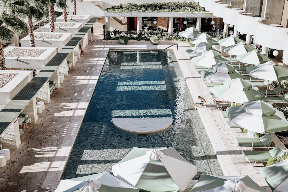 rectangular swimming pool surrounded with umbrellas