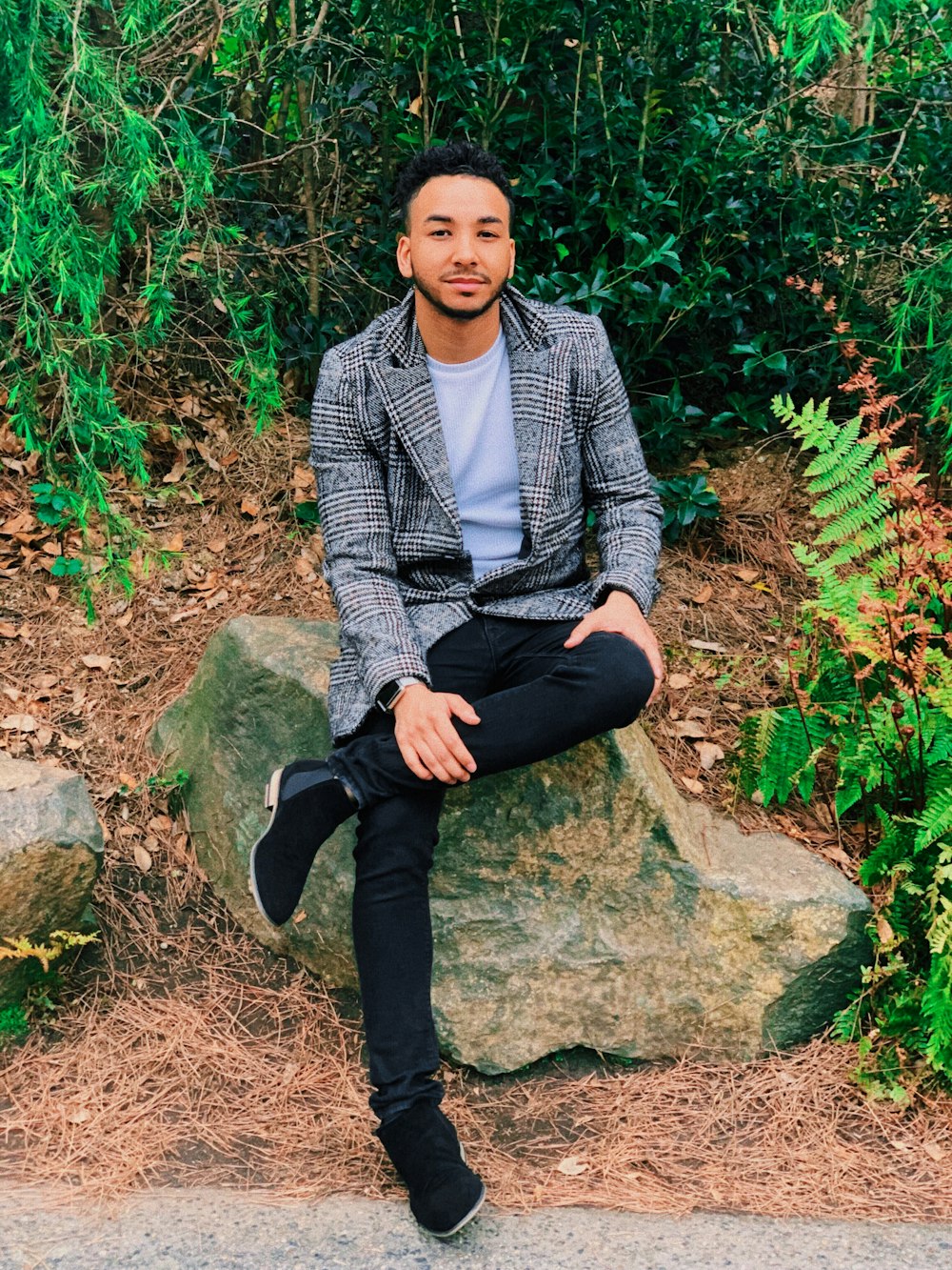 woman in gray and black blazer sitting on rock