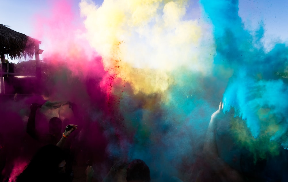 bue ,yellow, and pink powders in the air during daytime