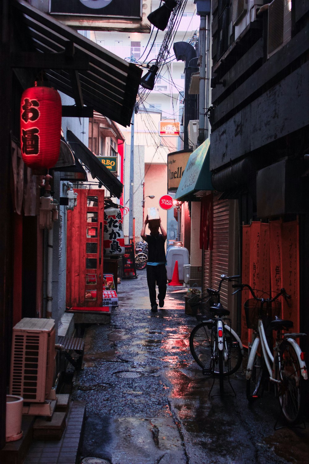 man walking with books on his head at the alley