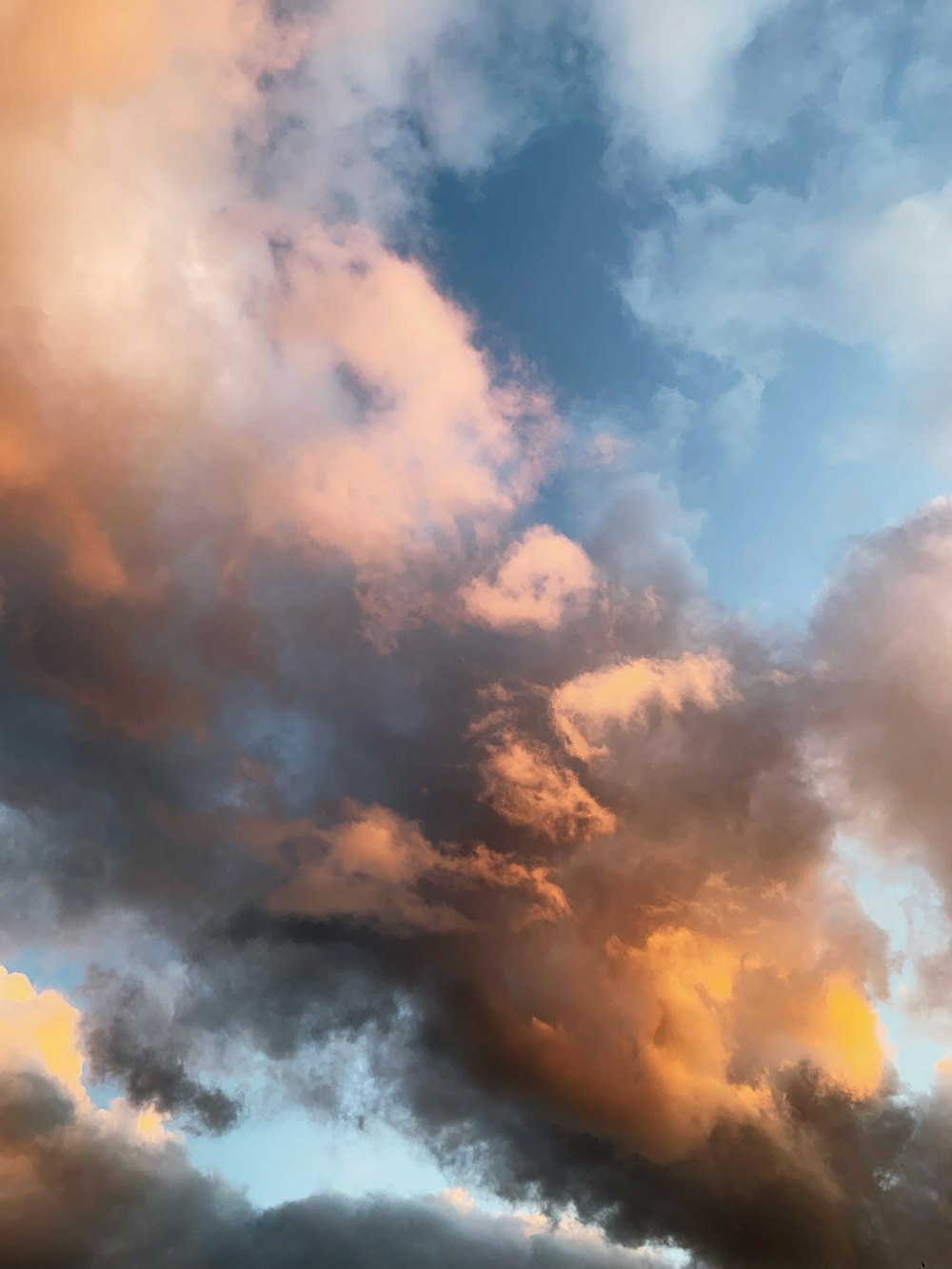 a plane flying through a cloudy blue sky