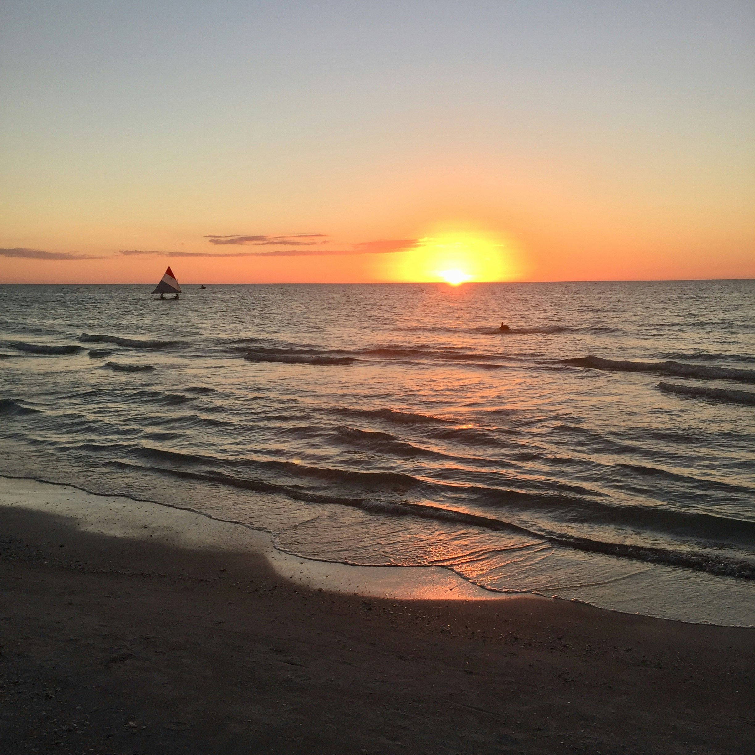 sailing boat on calm sea during sunrise