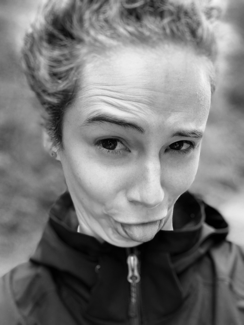 grayscale photo of woman showing tongue