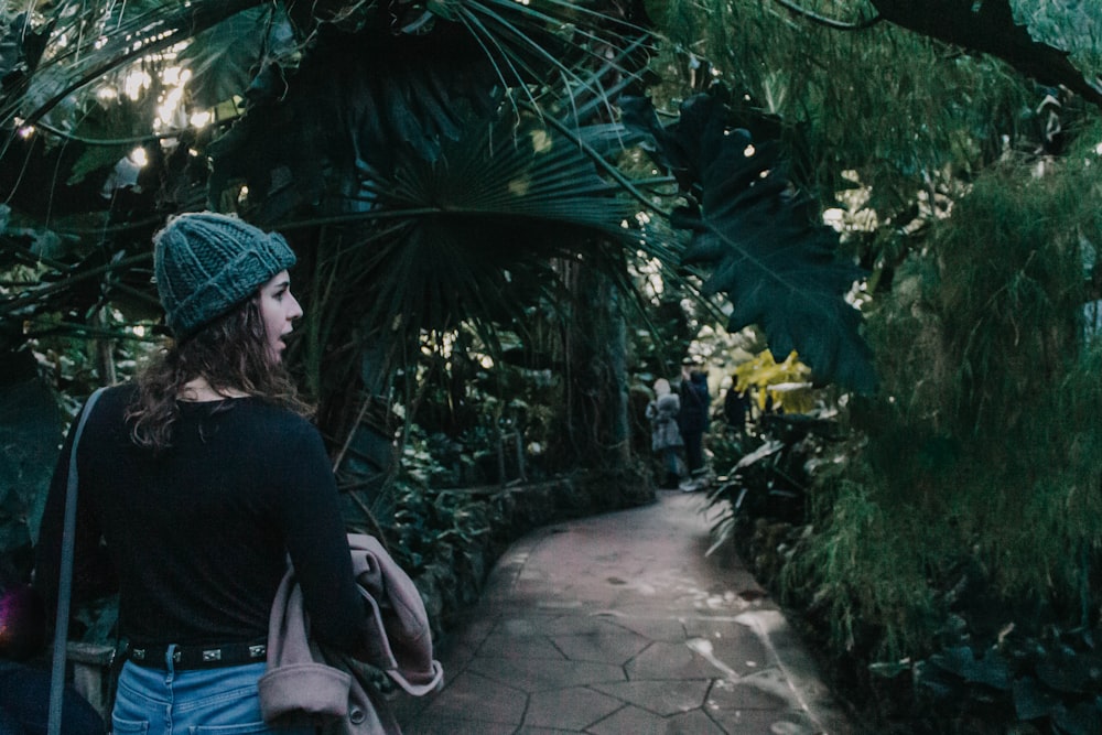 woman walking on concrete pathway looking her right side