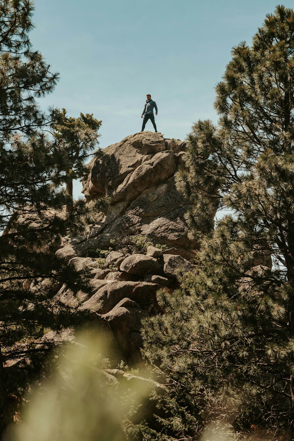 pessoa em pé na rocha sob o céu azul
