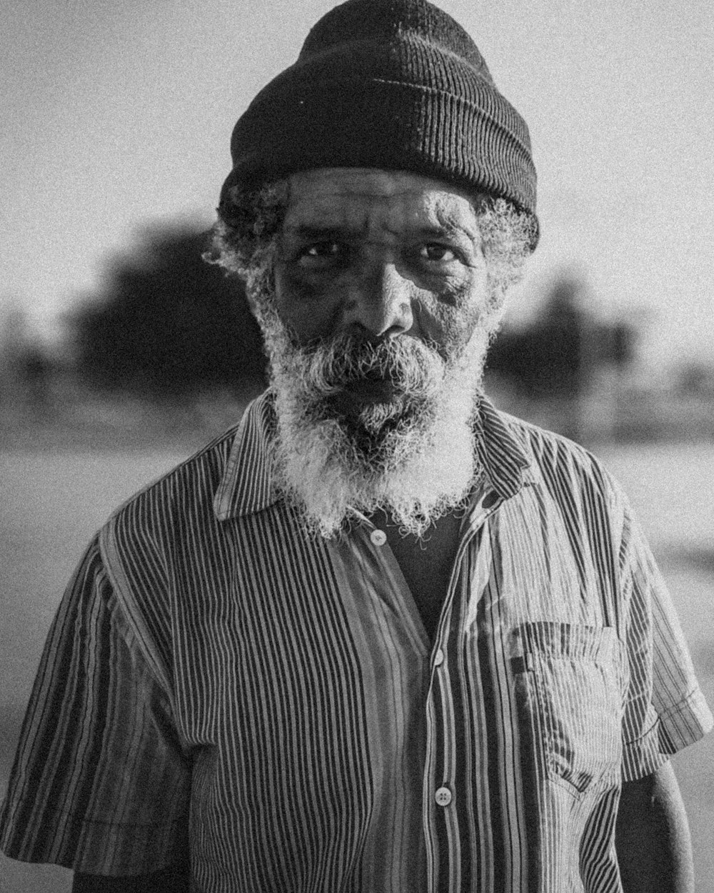 man wearing knit cap grayscale photo