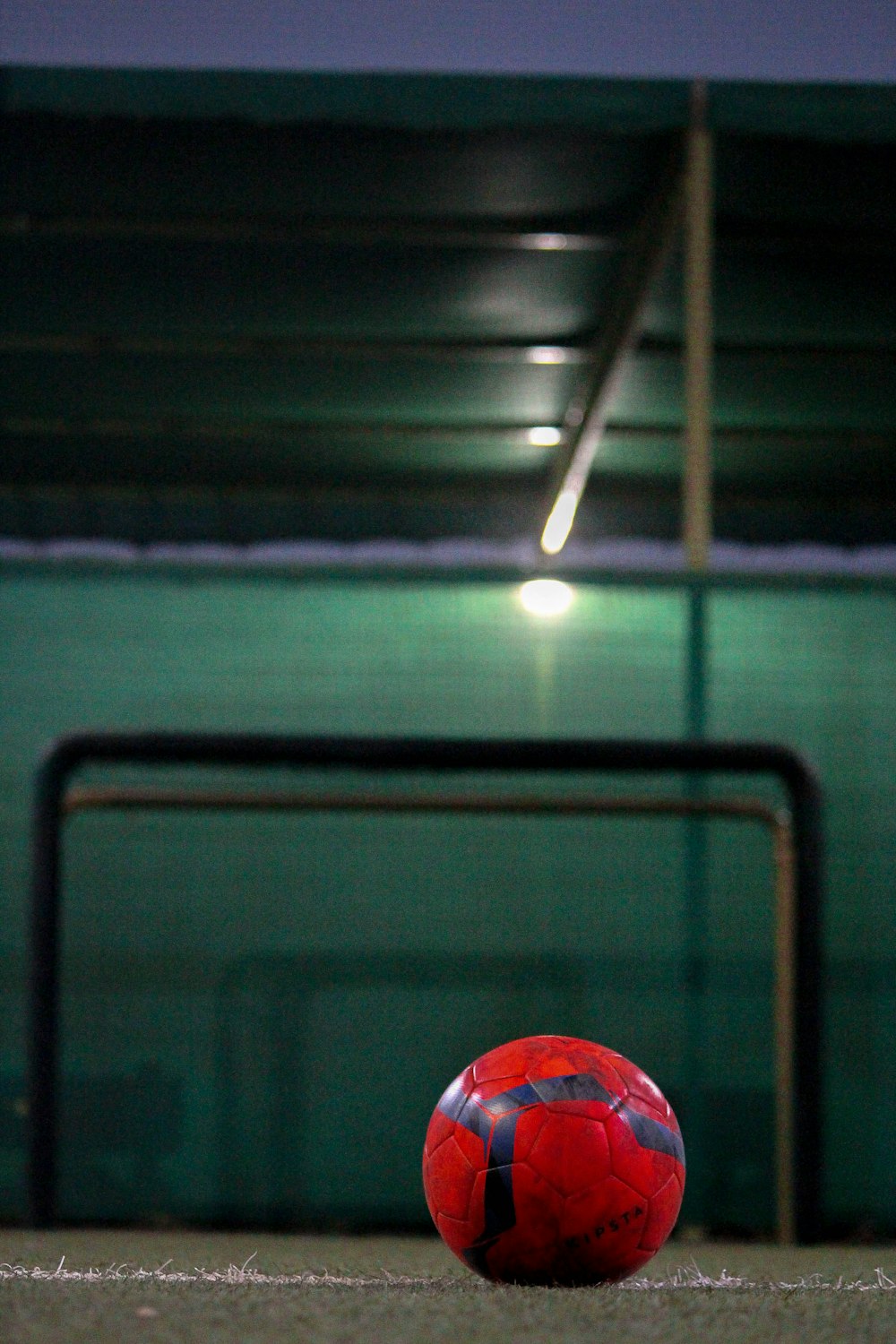 selective focus photography of red soccer ball on field