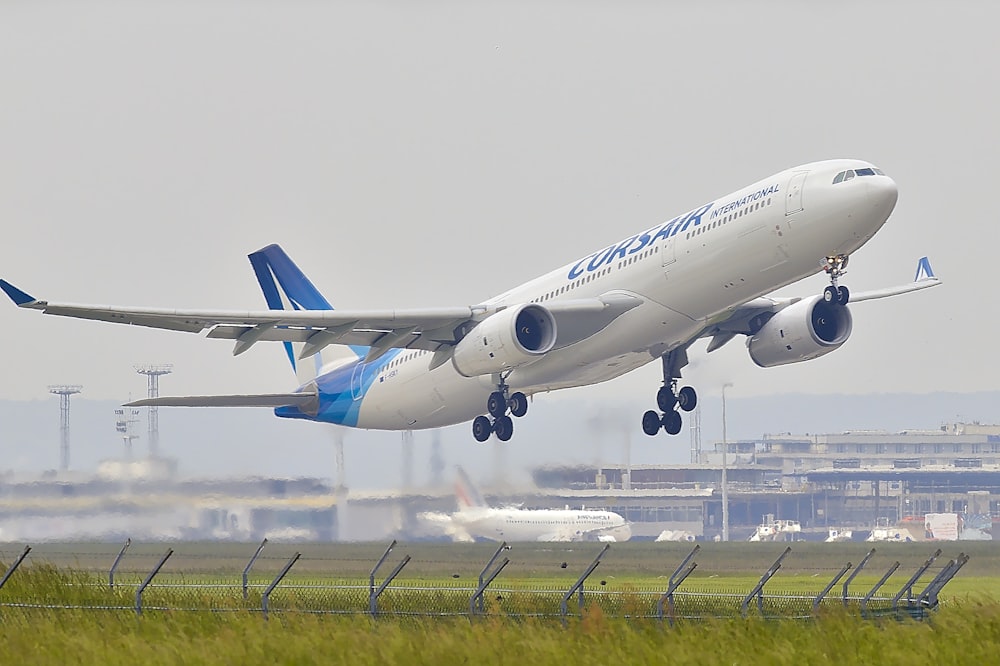 空港で飛ぼうとしている白と青の飛行機