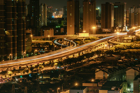 A stunning nighttime cityscape with glowing skyscrapers and lively streets reflecting the energy of urban travel.