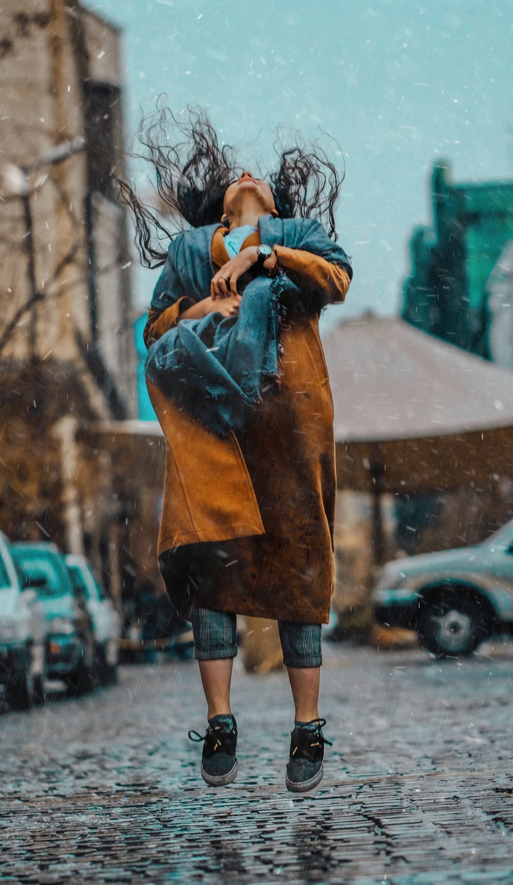 donna che salta sotto la pioggia