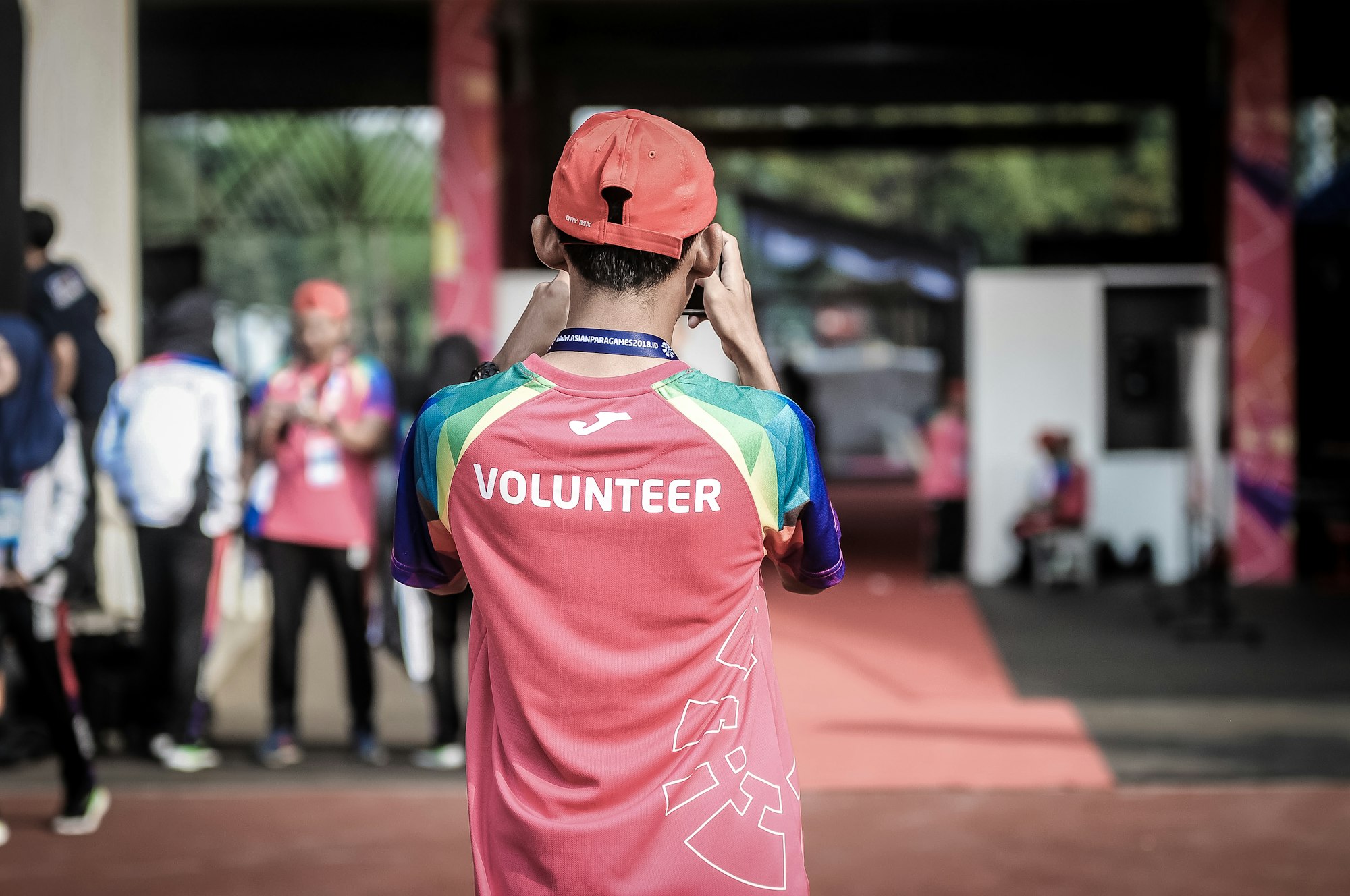 person standing wearing red volunteer shirt