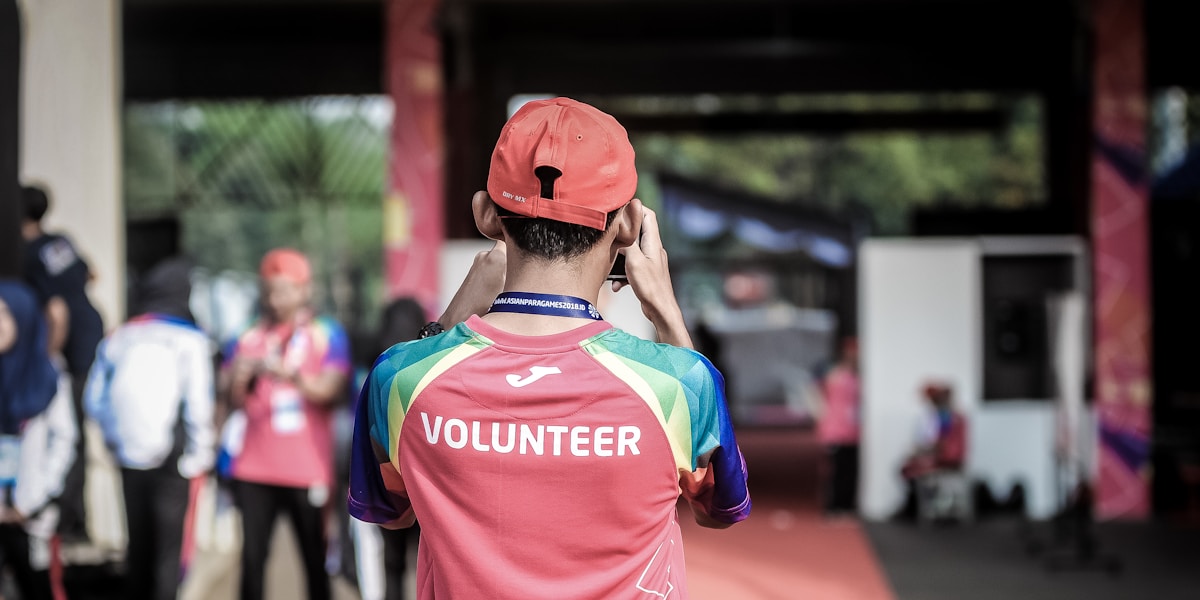 volunteer photographer (label on shirt)  from behind, shallow depth of field