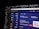 A computer screen displaying a digital wallet interface. Various cryptocurrencies like Bitcoin, Ethereum, and USD are listed with their respective balances. Options for depositing and withdrawing are available. A QR code is present next to a wallet address with a 'COPY' button.