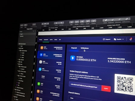 A computer screen displaying a digital wallet interface. Various cryptocurrencies like Bitcoin, Ethereum, and USD are listed with their respective balances. Options for depositing and withdrawing are available. A QR code is present next to a wallet address with a 'COPY' button.