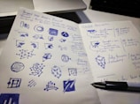 A close-up of a designer sketching logo concepts on paper.
