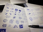 Creative designer sketching branding ideas on a notepad.