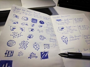 A designer sketching logo concepts on paper with colorful pencils.