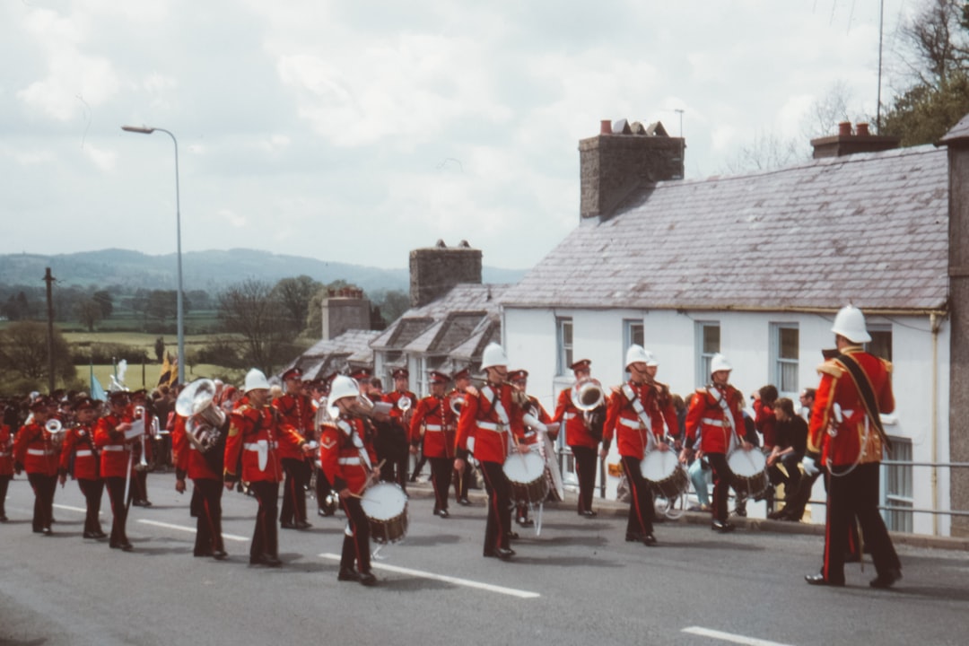 group of men in red uniform playing assorted instruments at the road