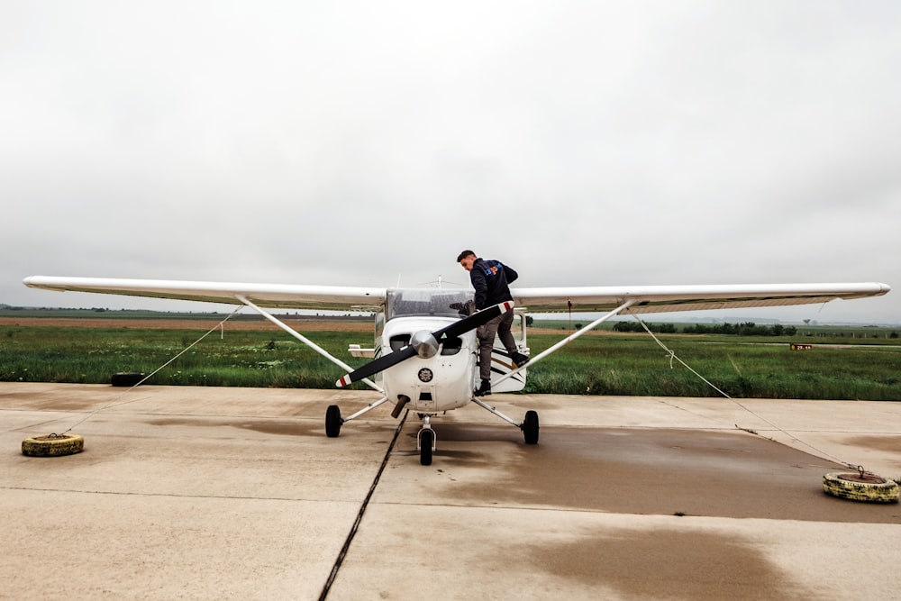 man riding white plane during daytime