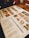 A restaurant menu placed on a wooden table, featuring images and prices of various dishes and drinks. The menu includes sections for starters, main courses, and beverages, with detailed photographs of each item. Items like baked goods, pasta, and drinks are highlighted.