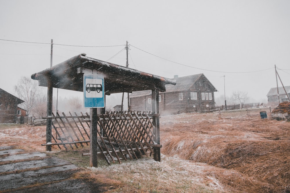 black bus stop near house during cloudy day