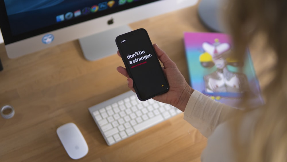 person holding black iPhone displaying don't be stranger