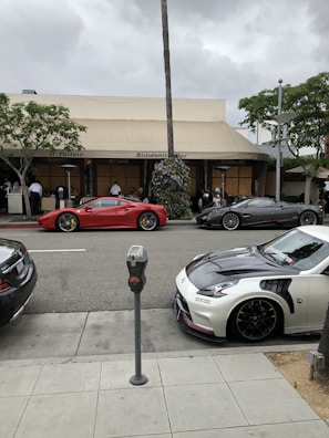 Shiny high-end sports cars lined up as part of valet parking at a bustling restaurant.
