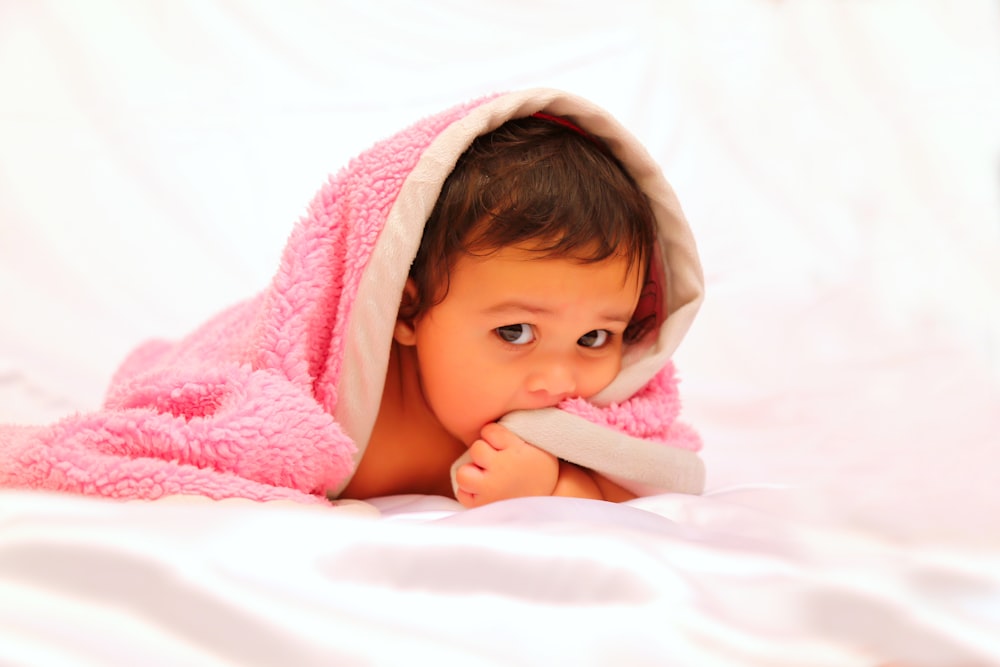baby under pink towel