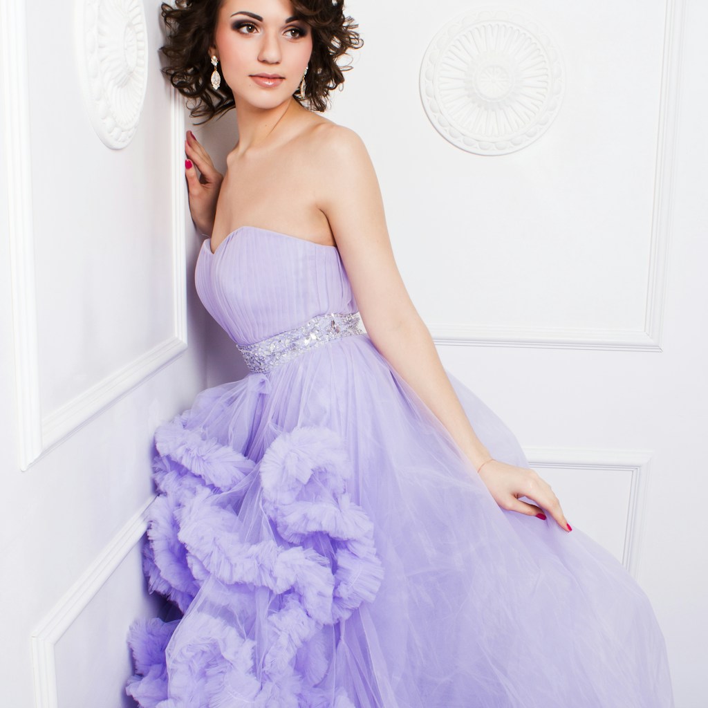 woman in purple strapless wedding dress leaning on wall