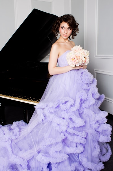 woman in purple off-shoulder dress holding bouquet of flowers